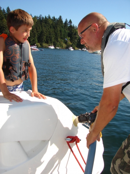 A man looking up at a little boy from a boat.