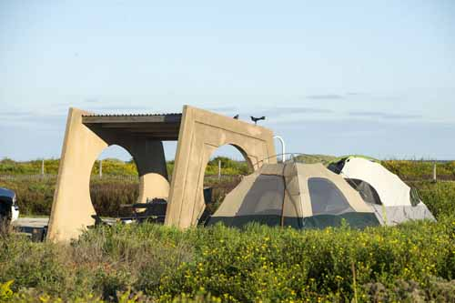 Tents next to a concrete structure.