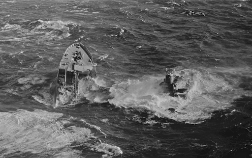 A black and white photo of a sinking vessel.