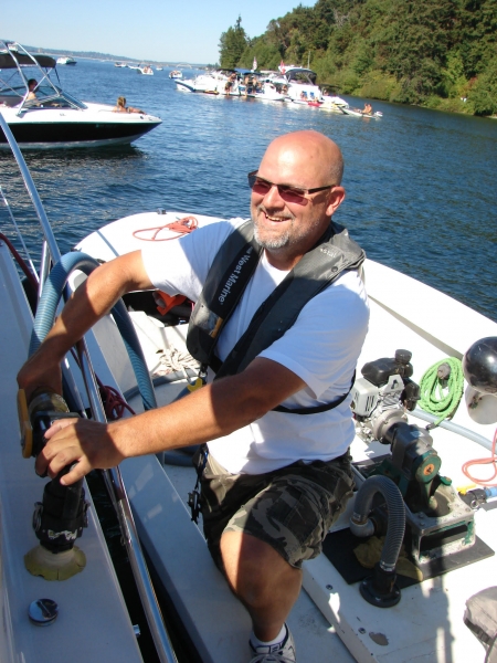 A man using a pump on a boat. 