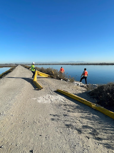 Cleanup workers moving pollution boom.