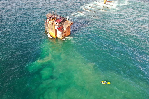 Oil coming from a platform in the water.