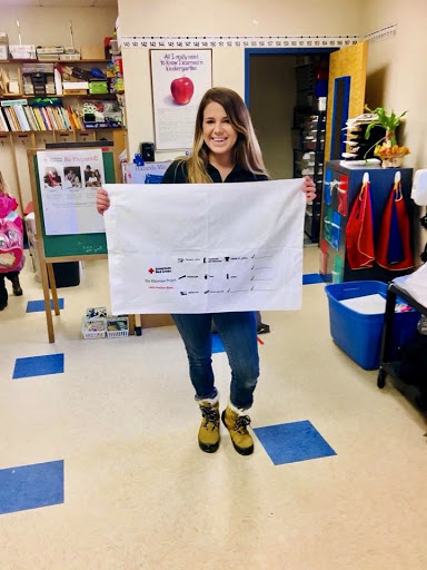 A person holding up a large sheet of paper.