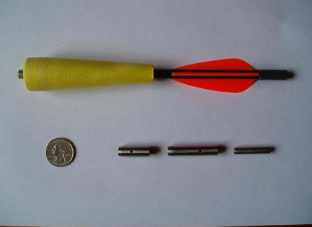 An image of a dart next to a quarter.