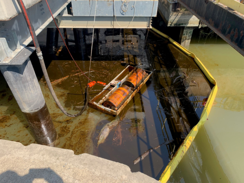 Oil skimming operation at terminal, surrounded by spill boom.