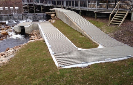 A path leading from a building down to a fishway that runs under the building.