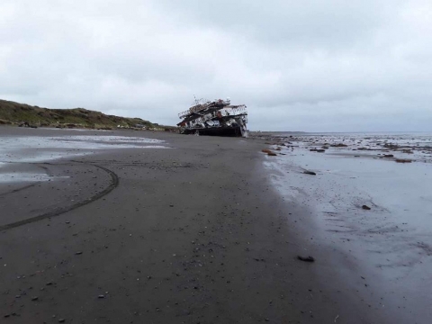 A grounded barge on a beach. 