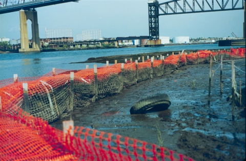 A muddy construction site near a bridge.