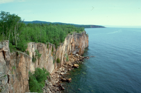 A rocky cliff side with water below.