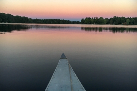 Sunset on a lake as seen from a kayak or a paddleboard.