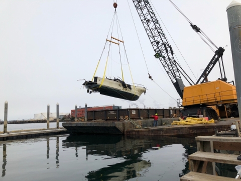 A boat being lifted from the water.