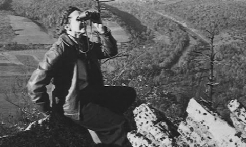 A woman looking through a pair of binoculars. 