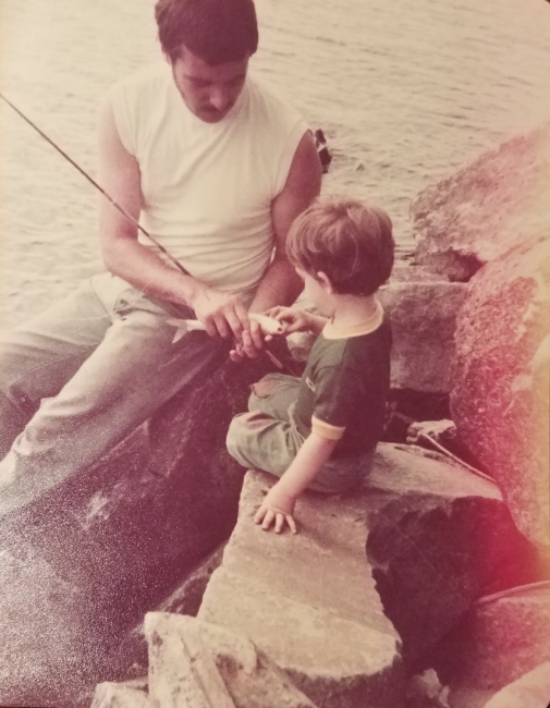 A father and son fishing at a lake.