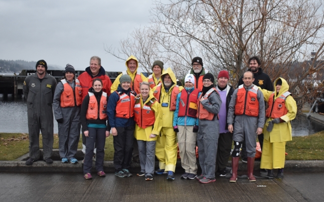 A group of people in life jackets pose for a photo. 