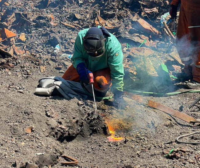 A worker putting out a small fire.