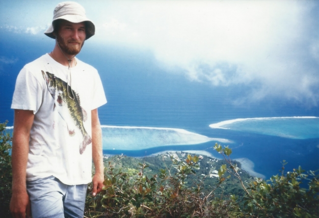 A man standing in front of a mountain landscape. 