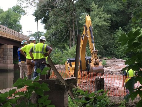 Workers and heavy equipment at a river work site. 