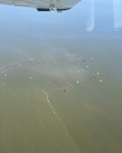 Aerial photo of response operations during a pollution leak in an open water environment.