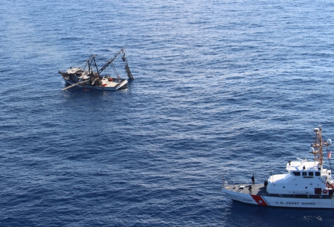 Smoke pluming from a vessel in water with another vessel approaching. 