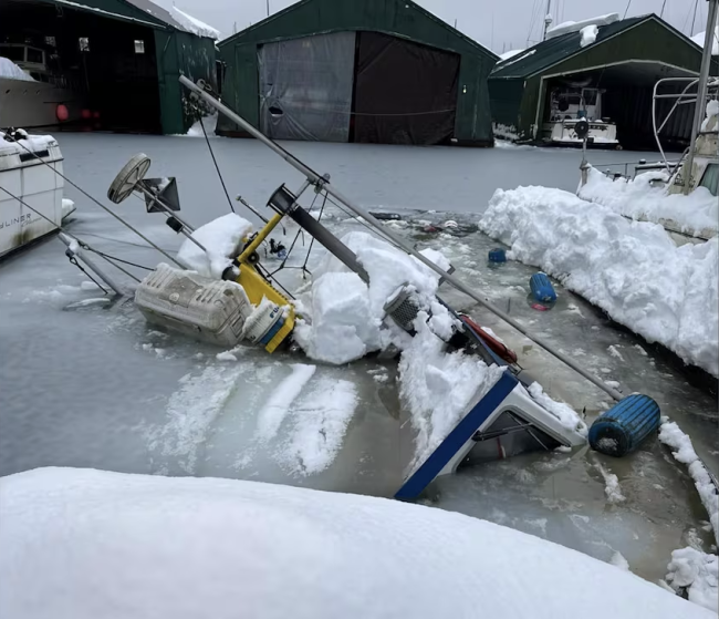 A boat sits submerged in the Juneau city harbor.