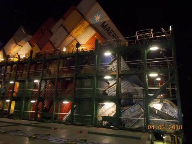 Rows of shipping containers tilting over on a vessel. 