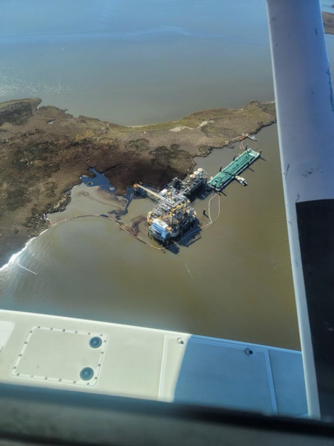 Aerial image of oil in water near an industrial site.