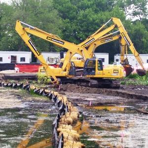 Construction vehicles on a shoreline.