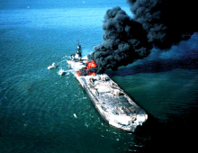Ship in the water spewing black smoke.