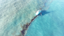 Response vessel skims crude oil in coastal waters