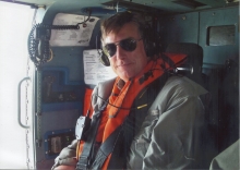 A man in a life vest on a helicopter.