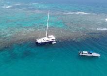 A sailing vessel aground on a coral reef in Puerto Rico; A vessel from an emergency spill response contractor can be seen in the lower right. 