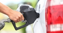 A person's hand as they pump gasoline into a vehicle. 