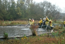 Workers spraying sediment with water. 