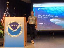A girl standing next to a podium with a NOAA logo on it.