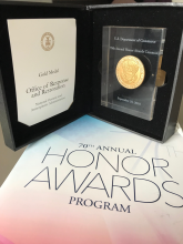 A photo of an award that reads "Gold Medal Office of Response and Restoration" on a table with a paper reading "70th Annual Honors Awards Program."