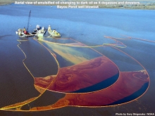 An aerial view of varying shades of oil being collected in pollution boom. 