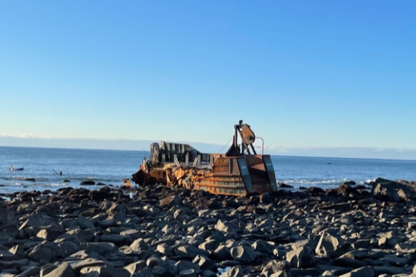 A vessel on a rocky shore.