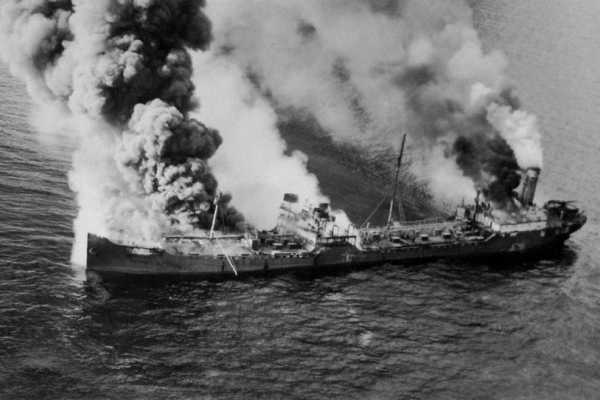 A vessel with smoke billowing up from multiple points. 