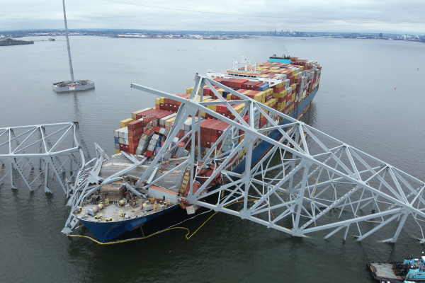 An aerial view of a bridge collapsed on a cargo ship that crashed into it.